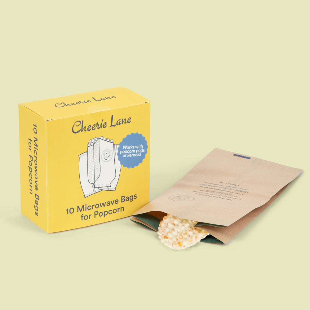 Yellow box of Cheerie Lane microwave popcorn bags with a single bag open on a light green background