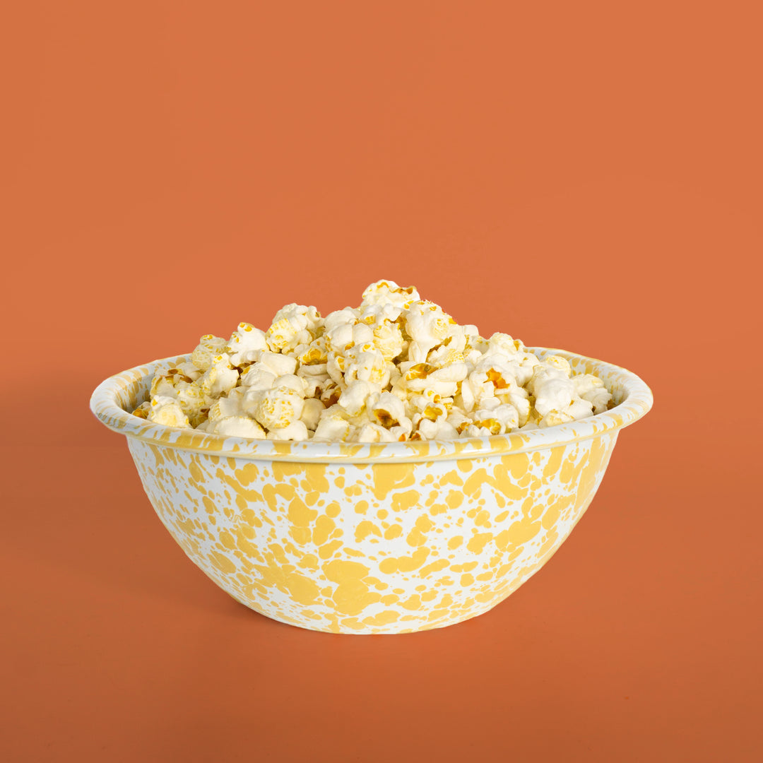 Bowl of popcorn with a yellow and white pattern on an orange background