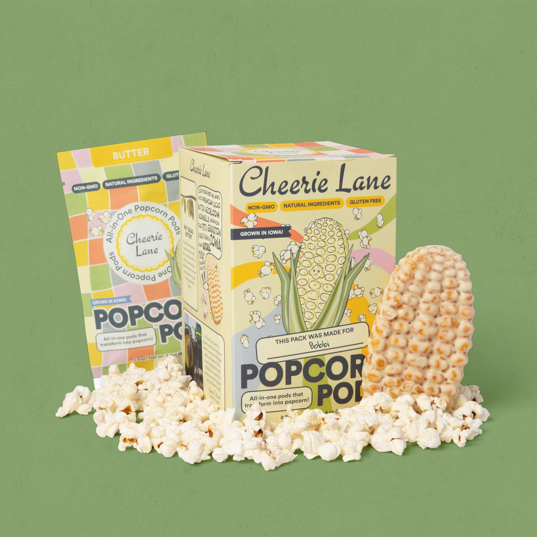 Cheerie Lane popcorn packaging with popcorn kernels and popcorn on a green background