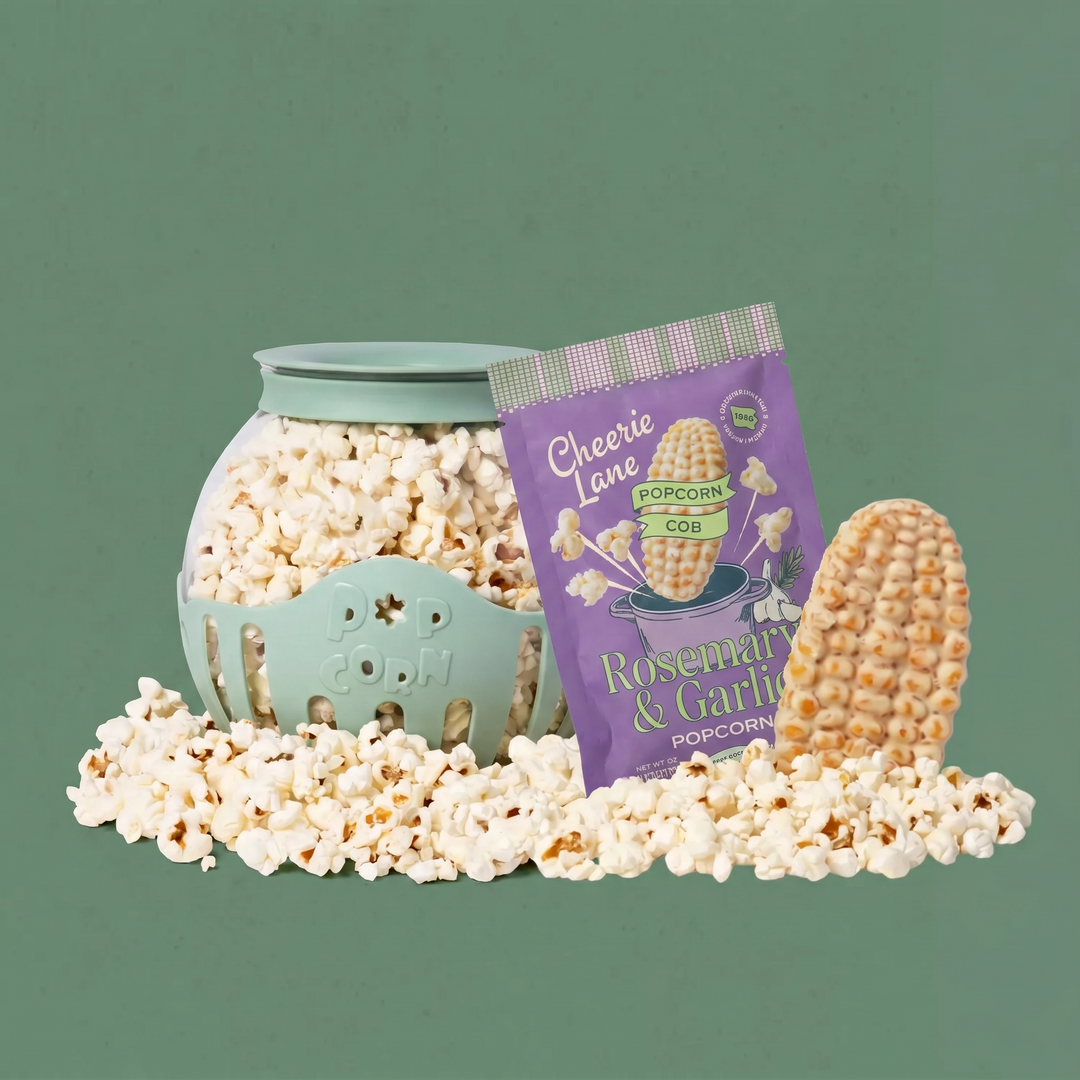 Popcorn in a teal container with a purple package labeled 'Cheerie Lane Popcorn' on a green background
