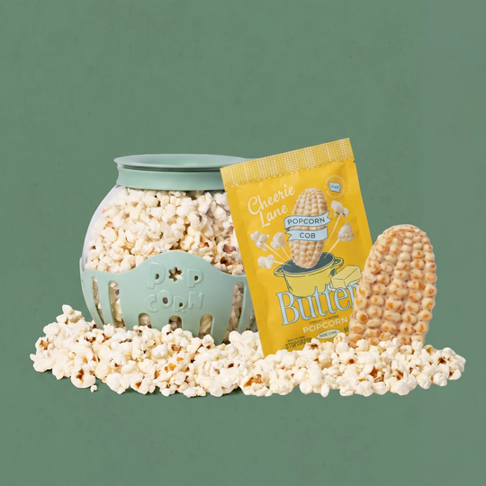 Popcorn in a teal container with a yellow 'Cheerie Lane' popcorn bag on a green background