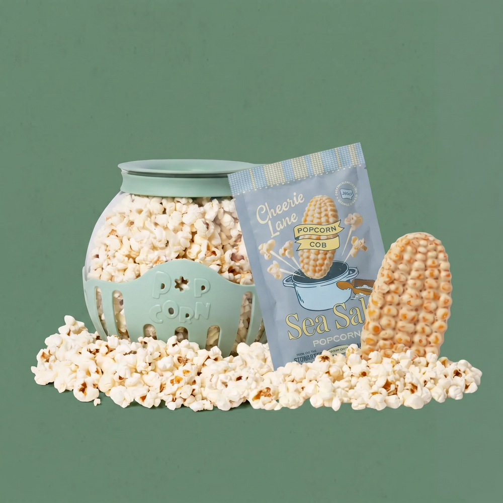 Popcorn in a green container with a packet of sea salt popcorn on a green background